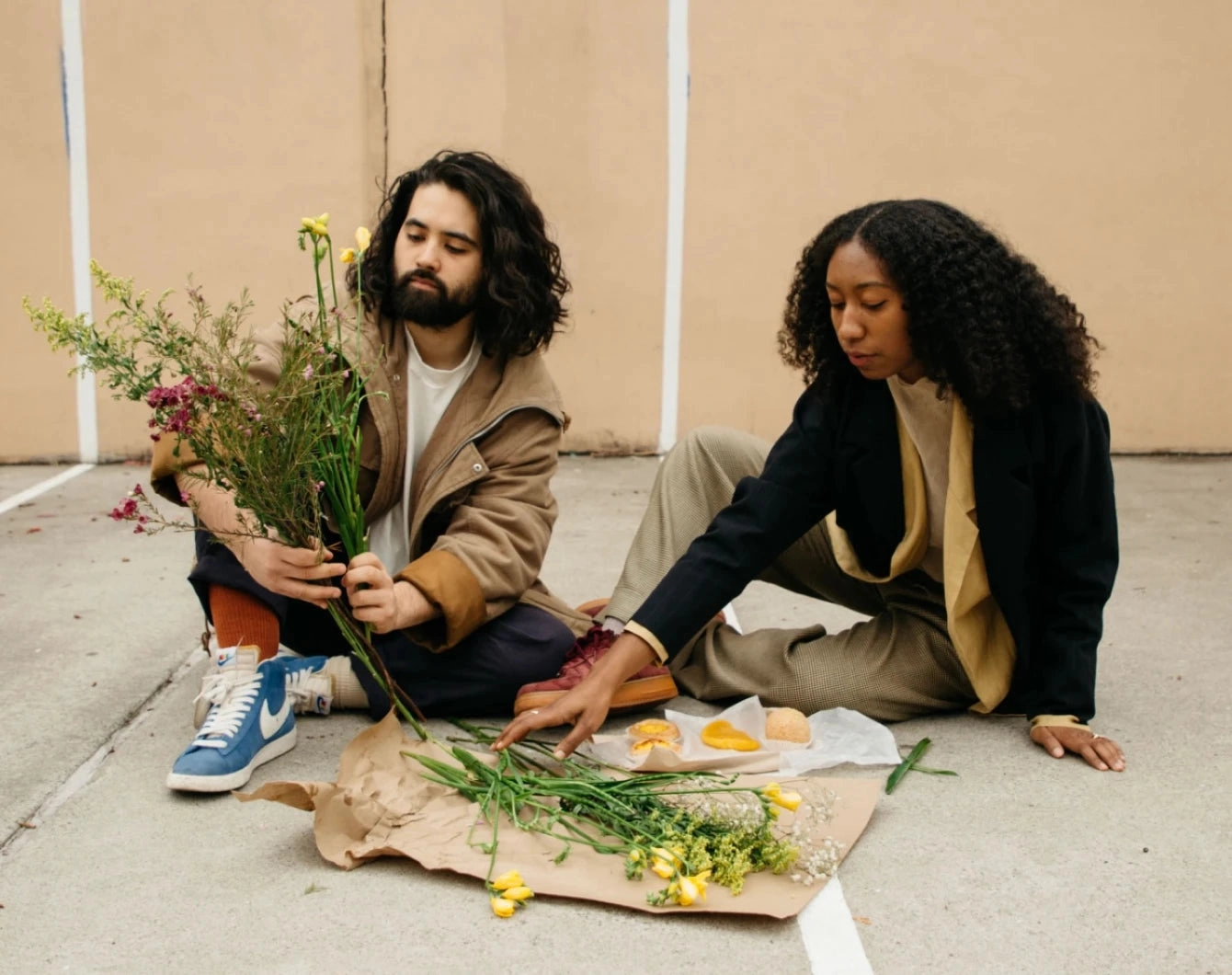 Our Story: Trinity and Issey sitting on the floor arranging flowers